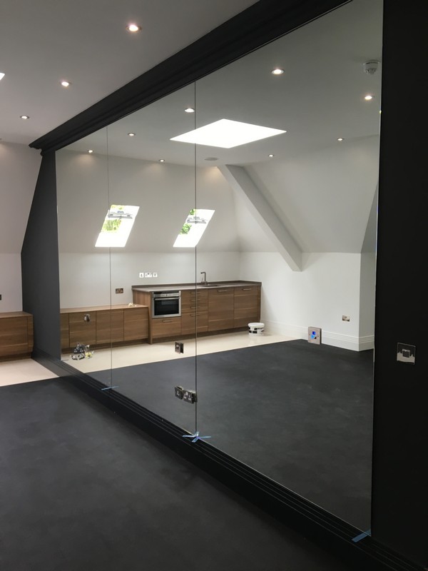 Frameless glass partition in loft conversion by Swiss Cottage glaziers