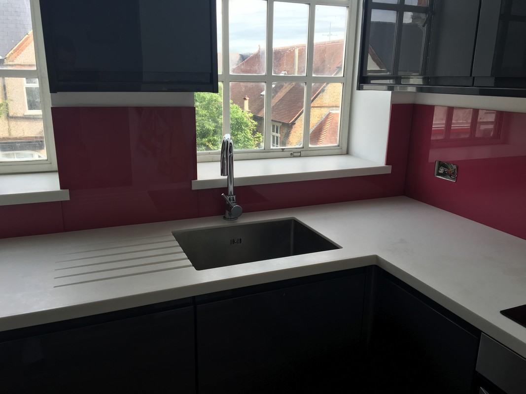 Deep plum coloured glass splashback in modern Swiss Cottage kitchen
